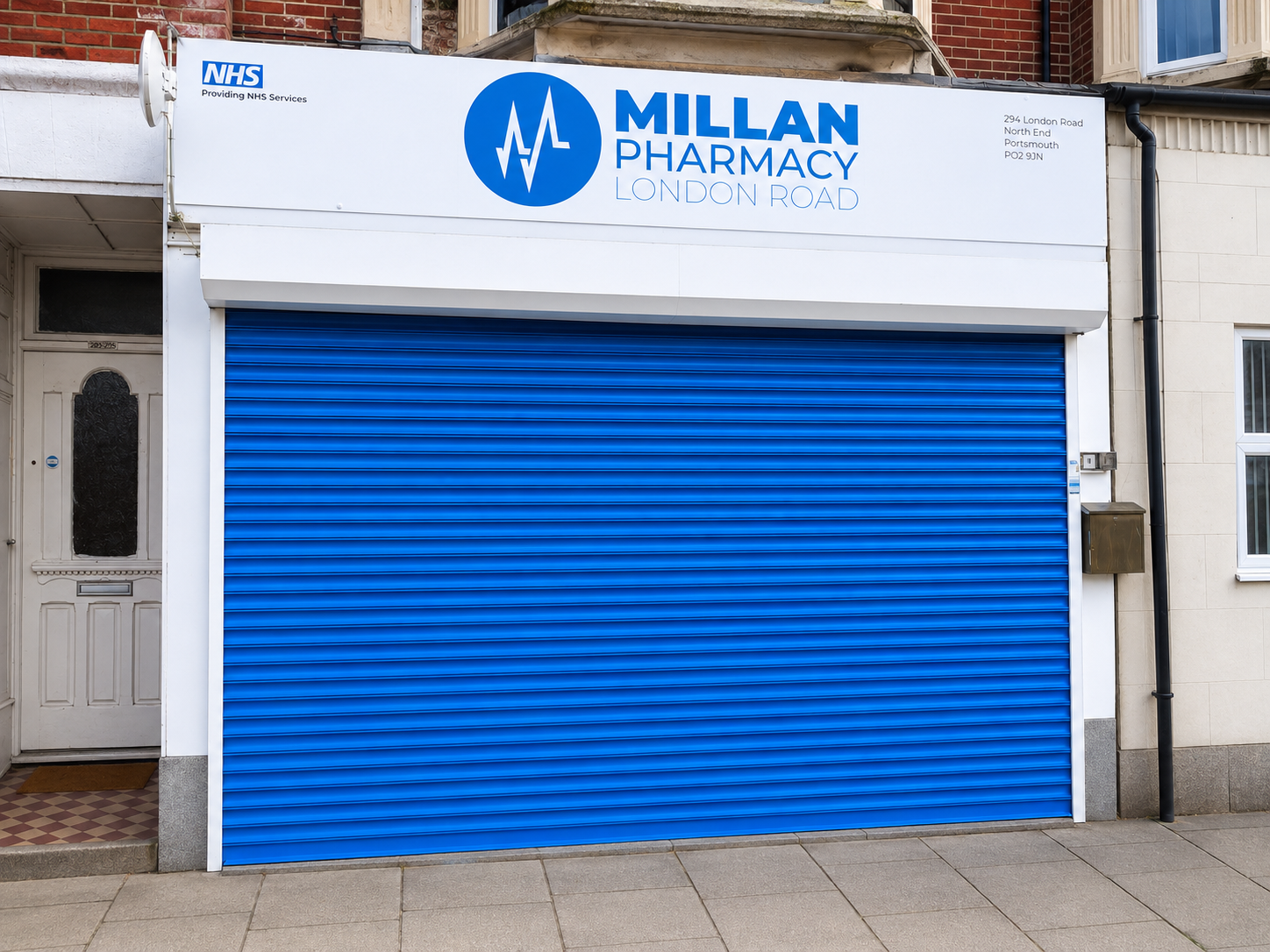 Millan Pharmacy London Road storefront with security shutter closed